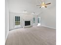 Bright living room featuring fireplace, ceiling fan, and large windows at 1307 Chandler Nw Ct, Acworth, GA 30102