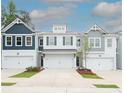 Charming townhome showcasing a well-manicured lawn, multi-car garage, and diverse exterior paint scheme at 2688 Ne Almand Ln, Conyers, GA 30013