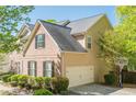 Side exterior featuring a two-car attached garage, basketball hoop, and well-maintained landscaping at 1010 Forest Creek Dr, Canton, GA 30115