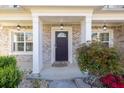 Inviting front porch with columns, stylish lighting, brick exterior, and well-maintained landscaping at 3448 Clear Stream Ne Run, Auburn, GA 30011