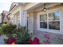 Close-up of front porch with decorative pillars, hanging lantern, brick facade, and lush landscaping at 3448 Clear Stream Ne Run, Auburn, GA 30011