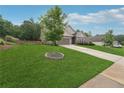 Beautifully landscaped front yard featuring a young tree, lush green grass, and welcoming curb appeal at 6340 Arlington Cir, Cumming, GA 30041