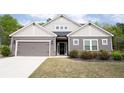 Traditional home featuring gray siding, a two-car garage, and manicured landscaping at 6340 Arlington Cir, Cumming, GA 30041
