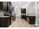 Well-equipped kitchen with stainless steel appliances, dark cabinets, and granite countertops at 739 Rolling Downs Dr, Loganville, GA 30052