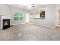 Cozy living room boasts fireplace, neutral paint, and an open layout to the kitchen at 739 Rolling Downs Dr, Loganville, GA 30052