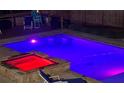 Inviting in-ground pool and hot tub with stone surround and colorful lighting for evening enjoyment at 632 Creekside Trce, Covington, GA 30014