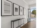 Bright foyer featuring stylish console table, modern artwork, and hardwood floors at 90 Hampton Ter, Dallas, GA 30157