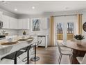 Modern kitchen boasts white cabinets, granite countertops, and stainless steel appliances at 90 Hampton Ter, Dallas, GA 30157