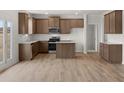 Modern kitchen featuring stainless steel appliances, wood cabinets, a center island, and light wood-look floors at 171 Hampton Ter, Dallas, GA 30157