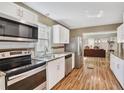 Open concept kitchen with stainless steel appliances, white cabinets, and hardwood flooring at 4076 Blanton Sw Ave, Atlanta, GA 30331