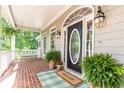 Welcoming front porch featuring a swing, plants, and an elegant front door with sidelights at 415 Morgan Falls Chase, Canton, GA 30114