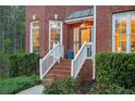 Inviting front porch with brick steps, white railings, and lush green landscaping, at dusk at 455 Cooper Woods Se Ct, Smyrna, GA 30082