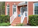 Inviting front porch with brick steps, white railings, and lush green landscaping at 455 Cooper Woods Se Ct, Smyrna, GA 30082