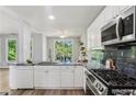 Bright kitchen with stainless appliances, granite countertops, and a view to the outdoor deck at 507 Mirramont Pl, Woodstock, GA 30189
