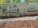 Stucco home featuring a large deck and stairs that leads to a wooded backyard at 3500 Lost Valley Dr, Jonesboro, GA 30236