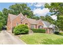 Charming brick house, including the driveway, with green lawns and mature trees at 1216 Beech Valley Ne Rd, Atlanta, GA 30306