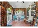 Relaxing front porch with hanging chairs, brick flooring, string lights, and space for outdoor seating at 1124 Larosa Sw Ter, Atlanta, GA 30310