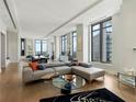 Well-lit living room with a sleek sectional sofa, modern decor, and panoramic views from floor-to-ceiling windows at 3376 Peachtree Ne Rd # 44B, Atlanta, GA 30326