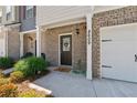 Welcoming entrance featuring a brick facade, lush greenery, and a convenient attached garage at 8609 Lakeview, Jonesboro, GA 30238