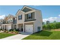 Two-story townhome with a well-maintained lawn, brick accents, and attached garage on a sunny day at 8609 Lakeview, Jonesboro, GA 30238