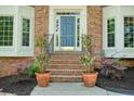 Charming entryway with brick steps, potted plants, and bay windows at 120 Stanmore Ct, Roswell, GA 30075