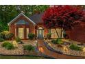 Beautifully landscaped front yard with manicured shrubbery and walkway to front door at dusk at 235 Huiet Dr, Mcdonough, GA 30252