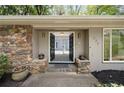 Close up of a stone accented house with black double doors and fresh landscaping at 239 Devonwood Dr, Atlanta, GA 30328