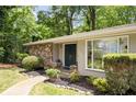 Inviting front entrance with stone details, fresh landscaping, and a modern double door for a sophisticated welcome at 239 Devonwood Dr, Atlanta, GA 30328