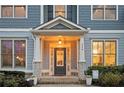 Close-up of home's front door with sidelights, decorative plants, manicured shrubbery and address numbers at 520 Tackett Farms Rd, Smyrna, GA 30082