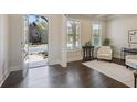 Bright foyer with dark hardwood floors, neutral walls, and a view of the home's exterior through the front door at 3065 Arbor Song Ct, Cumming, GA 30041