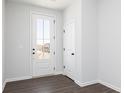 Bright foyer featuring a glass-paneled door, dark hardwood floors, and white walls at 520 Aberdeen Mdw, Acworth, GA 30102