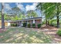 Cozy brick home featuring mature trees, manicured lawn, and classic architectural details at 190 Sunrise Cir, Riverdale, GA 30274