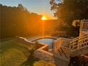 Backyard pool at sunset with well-maintained lawn and elegant stone patio at 177 Grandmar Chase, Canton, GA 30115