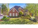 Beautiful two-story brick home featuring a manicured lawn and lush landscaping at 177 Grandmar Chase, Canton, GA 30115