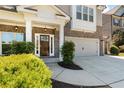 Close-up of a brick and siding home, highlighting the front entrance, garage, and beautifully landscaped front yard at 1862 Lake Ebenezer Trl, Marietta, GA 30066