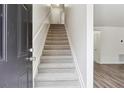 Inviting staircase leading to the upper level, with neutral carpeting and white walls at 4282 Worth Nw St, Acworth, GA 30101