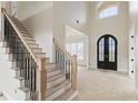 Bright foyer featuring a staircase with wooden steps and wrought iron railing and a double front door at 5694 Brendlynn Dr, Suwanee, GA 30024
