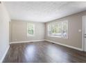 Bright living room featuring wood-look flooring, neutral walls, and ample natural light from the large windows at 2041 W Flat Shoals Ter, Decatur, GA 30034