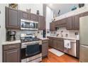 Kitchen with granite countertops, stainless steel appliances, decorative backsplash, and dark cabinets with chrome hardware at 624 Spanish Oak Dr, Acworth, GA 30102