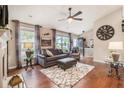 Bright living room with hardwood floors, a ceiling fan, neutral walls, and large windows that let in lots of natural light at 624 Spanish Oak Dr, Acworth, GA 30102