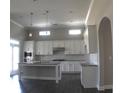 Modern kitchen featuring white cabinets, granite countertops, stainless steel appliances and stylish pendant lighting at 2925 Coach River Way, Cumming, GA 30040