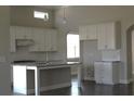 Bright kitchen featuring white cabinets, granite countertops, subway tile backsplash, and a center island at 2925 Coach River Way, Cumming, GA 30040