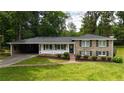 Traditional home with a neatly landscaped front yard and attached carport at 3925 Chicamauga Ne Dr, Kennesaw, GA 30144