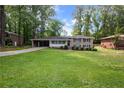Traditional brick home with expansive front lawn and covered parking, showcasing its curb appeal at 3925 Chicamauga Ne Dr, Kennesaw, GA 30144