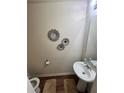 Powder room featuring pedestal sink, decorative flower art and neutral color scheme at 4039 Braxton Sw Pl, Atlanta, GA 30331