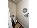 Cozy powder room with decorative flower art and neutral color scheme at 4039 Braxton Sw Pl, Atlanta, GA 30331
