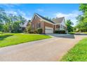 Side exterior view of brick home featuring an attached garage, driveway and manicured lawn at 1272 Saxony Se Dr, Conyers, GA 30013