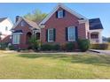 Beautiful brick home with dark shutters, a manicured lawn, and lush landscaping at 1272 Saxony Se Dr, Conyers, GA 30013