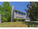 Home featuring a brick chimney, neutral siding, and well-manicured landscaping at 2386 Mills Bnd, Decatur, GA 30034