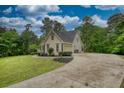 Traditional home featuring a long driveway and well-maintained lawn at 1761 Mcdaniel Mill Rd Sw, Conyers, GA 30094